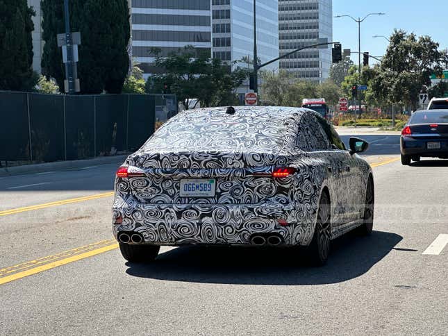 Rear 3/4 view of a camouflaged next-gen Audi S5 Sportback in traffic