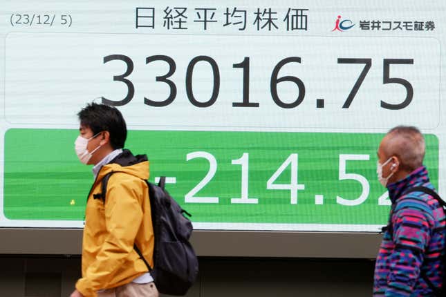 People walk in front of an electronic stock board showing Japan&#39;s Nikkei 225 index at a securities firm Tuesday, Dec. 5, 2023, in Tokyo. Asian shares declined in cautious trading Tuesday ahead of some key reports this week on the U.S. job market that might provide insight into the Federal Reserve’s thinking about interest rates.(AP Photo/Eugene Hoshiko)