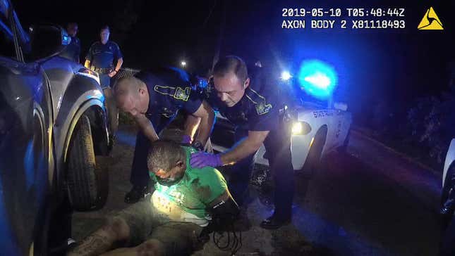 This image from the body camera of Louisiana State Police Trooper Dakota DeMoss shows his colleagues, Kory York, center left, and Chris Hollingsworth, center right, holding up Ronald Greene before paramedics arrived on May 10, 2019, outside of Monroe, La.