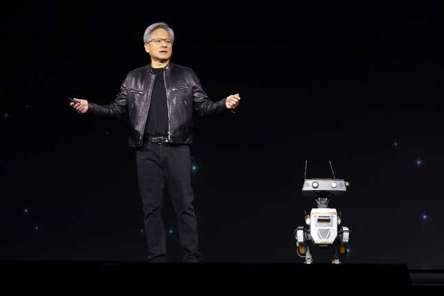 Jensen Huang standing beside a robot