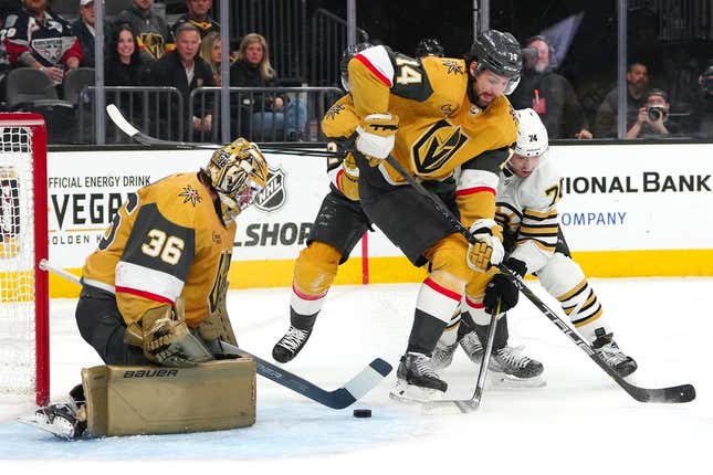 Jan 11, 2024; Las Vegas, Nevada, USA; Vegas Golden Knights goaltender Logan Thompson (36) makes a save as Vegas Golden Knights defenseman Nicolas Hague (14) fends off Boston Bruins left wing Jake DeBrusk (74) during the first period at T-Mobile Arena.