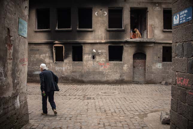 Diyarbakir residents survey damage in a commercial alleyway that recently reopened to the public, after being designated off-limits for more than three months.