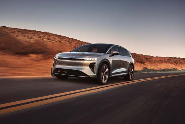 Lucid Gravity electric SUV in silver driving down a desert road