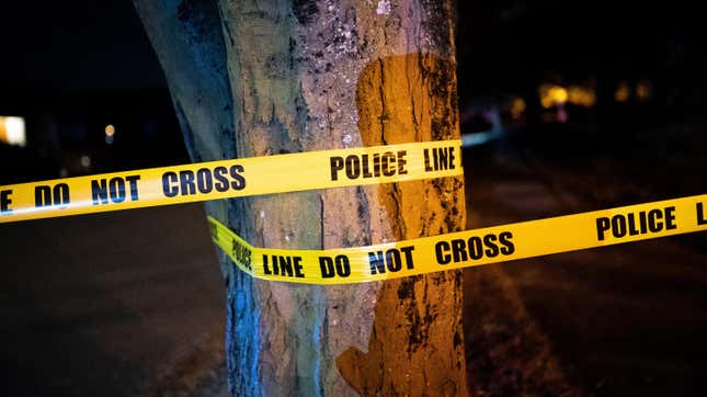 A Portland police officer cordons off a street during an investigation of gunfire near a protest on August 26, 2020 in Portland, Oregon. 