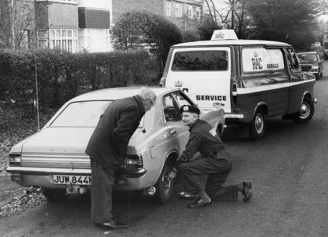 ca. 1970: Ein RAC-Mann repariert einen kaputten Ford Cortina.