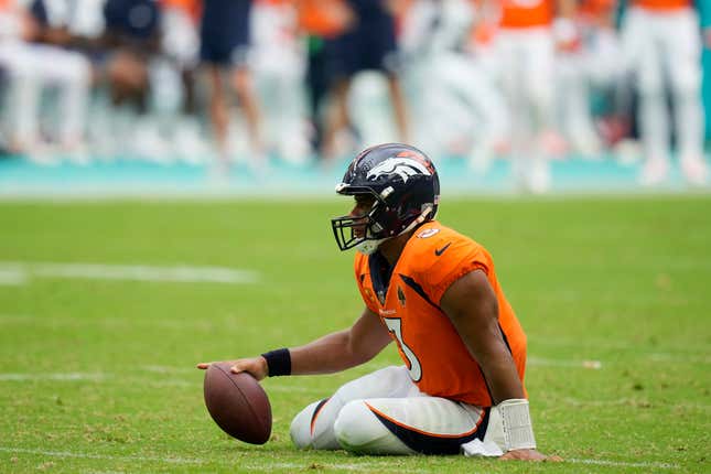 Denver Broncos QB Russell Wilson sits on the field after he was sacked during the second half of his team’s 70-20 loss to the Miami Dolphins. 