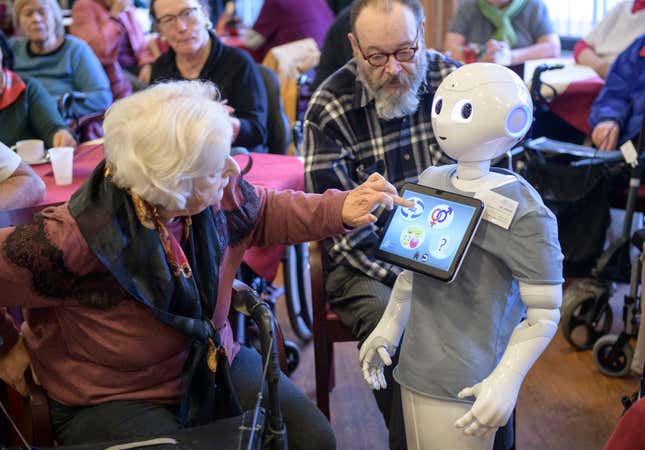 An elderly resident looks to Pepper during a presentation of two robots at the August-Stunz-Altenzentrum senior care facility on November 28, 2018 in Frankfurt, Germany. 