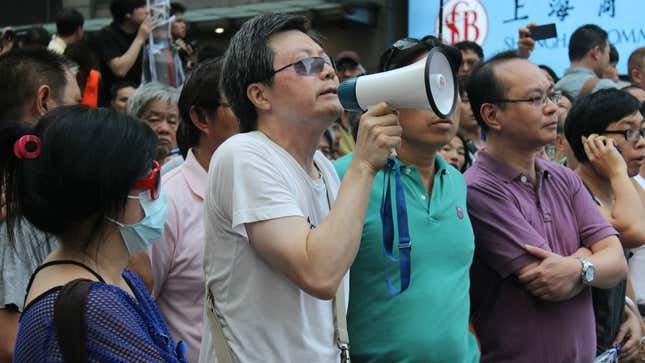 A man protesting against Occupy Central in Mong Kok yelled from a megaphone, “You can’t stop our children from going to school.”