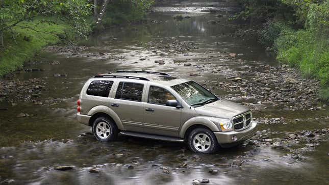 A silver Dodge Durango parked in a river. 