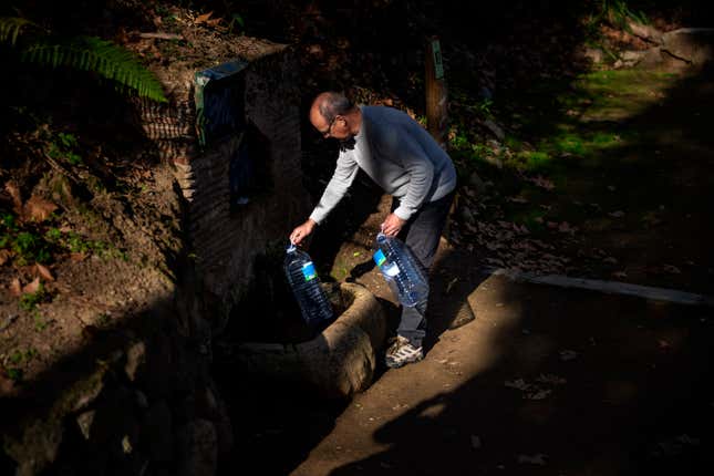 Joan Torrent, 64, fills plastic jugs at a natural spring in Gualba, about 50 km, (31 miles) northwest of Barcelona, Spain, Wednesday, Jan 31, 2024. Joan trudges almost every day into the woods in search of drinking water. Spain&#39;s northeast Catalonia is preparing to declare a drought emergency for the area of some six million people including the city of Barcelona. But thousands of people who live in villages and towns in the Catalan countryside have already been in full-blown crisis mode for several months. (AP Photo/Emilio Morenatti)