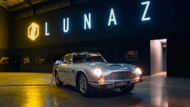 A silver Aston Martin DB6 plugged in to charge 