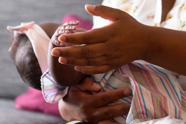 Asian Davis, 33, of Sikeston, Mo., cradles her 8-month-old daughter Mira White, during an interview on Oct. 3, 2023, in St. Louis. Davis and her lawyers say Mira suffered brain damage in March after developing bacterial meningitis tied to powdered infant formula contaminated with Cronobacter sakazakii, a germ known to cause severe disease in young babies. (AP Photo/Michael Thomas)