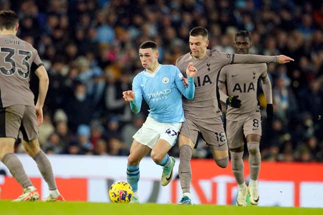 Tottenham&#39;s Giovani Lo Celso vies for the ball with Manchester City&#39;s Phil Foden, center, during the English Premier League soccer match between Manchester City and Tottenham Hotspur at Etihad stadium in Manchester, England, Sunday, Dec. 3, 2023. (AP Photo/Dave Thompson)