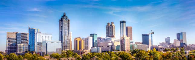 Downtown Atlanta Skyline showing several prominent buildings and hotels under a blue sky.
