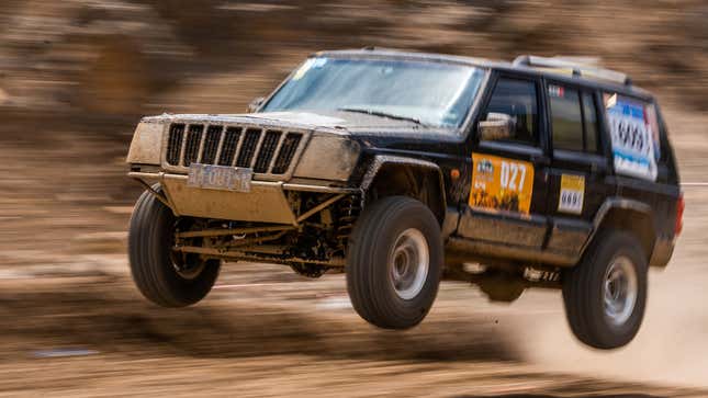 A photo of a Jeep jumping on an off-road course. 