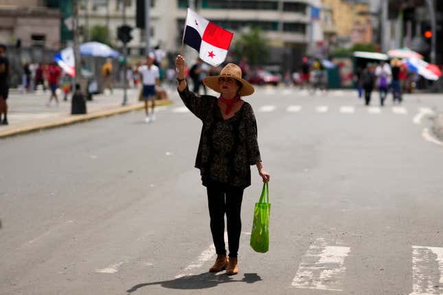 A woman waves a Panamanian national flag during a protest against a mining contract between the Panamanian government and the Canadian mining company First Quantum in Panama City, Friday, Nov. 3, 2023. (AP Photo/Arnulfo Franco)