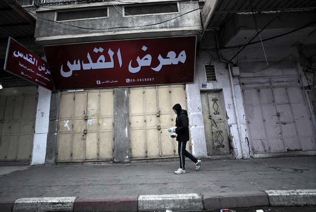 A man walks next to closed shops during a strike in Gaza City.