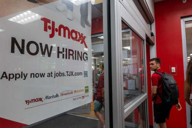 Un homme entre dans un magasin où il y a un panneau « TJ Maxx recrute maintenant »