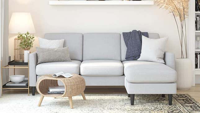 The light gray linen sofa inside a living room.