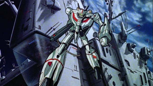 A Veritch in robot mode strikes a pose in front of the giant Macross spaceship as it sails through space.