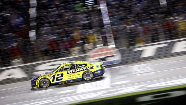 Ryan Blaney crosses the finish line at 2022&#39;s NASCAR All-Star Race. His window net has fallen after he attempted to re-secure it.