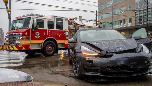 A wrecked Tesla in front of a fire truck