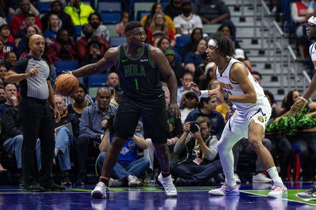 Nov 17, 2023; New Orleans, Louisiana, USA;  New Orleans Pelicans forward Zion Williamson (1) dribbles against Denver Nuggets forward Zeke Nnaji (22) during the first half at the Smoothie King Center.