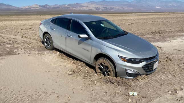 A silver Chevy Malibu stuck in the mud in Death Valley. 