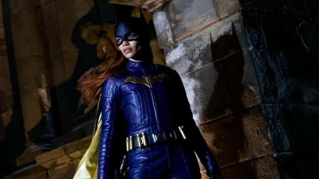 Leslie Grace as Batgirl in a promotional still, standing on a building in Gotham and looking out to the distance. 