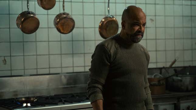 Isaac looks at something off-screen in a kitchen.