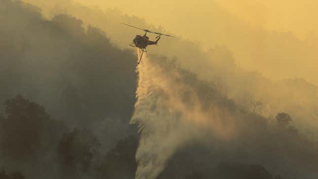 A firefighting helicopter dropping water on a forest fire 