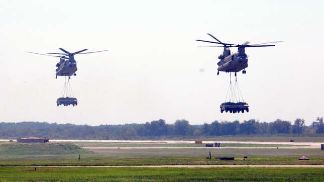 Dos Chinook CH-47 sobrevuelan el aeródromo del ejército de Campbell para dejar dos HMMWV cada uno durante un evento de asalto aéreo para el Super Saturday Air Espectáculo en Fort Campbell, Ky., 11 de agosto.