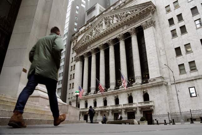 FILE — People pass the front of the New York Stock Exchange, March 22, 2023. The average Wall Street bonus fell slightly last year to $176,500 as firms took a “more cautious approach” to compensation, New York state’s comptroller reported Tuesday, March 19, 2024. (AP Photo/Peter Morgan, File)