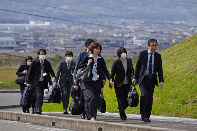 Japan&#39;s health ministry officials walk towards a plant operated by a subsidiary of Kobayashi Pharmaceutical Co. to conduct an on-site inspection in Kinokawa, south of Osaka, western Japan, Sunday, March 31, 2024. Japanese government health officials on Sunday inspected a factory producing health supplements linked to several deaths and the hospitalization of more than 100 others, one day after the authorities investigated another plant that manufactured the product. (Yohei Fukai/Kyodo News via AP)