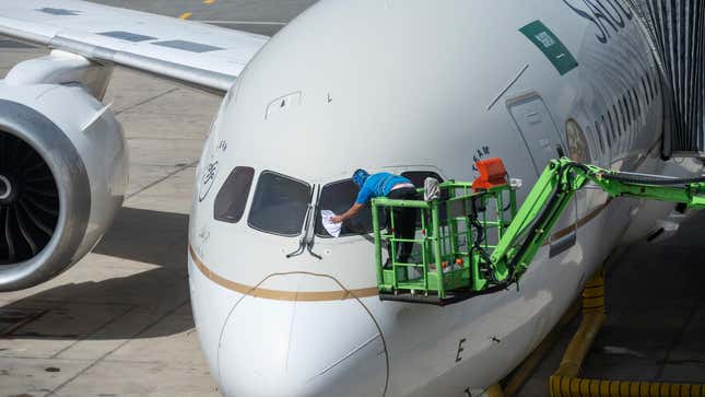 A worker cleans the front window of a flag carrier Saudi Arabia, Saudi airline, plane seen at the Jeddah (Yidda) international airport runway.
