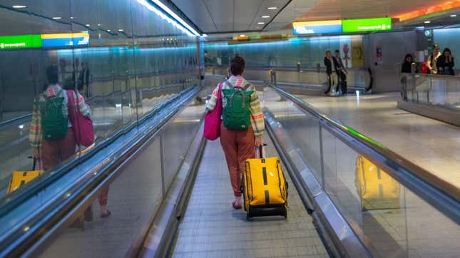 A traveler on a moving walkway at Heathrow Airport