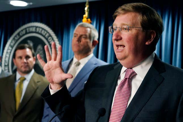 House Speaker Philip Gunn, R-Clinton, center, listens as Republican Gov. Tate Reeves, speaks about signing a bill that will reduce the state income tax over four years, beginning in 2023, at his office in Jackson, Miss., Tuesday, April 5, 2022.