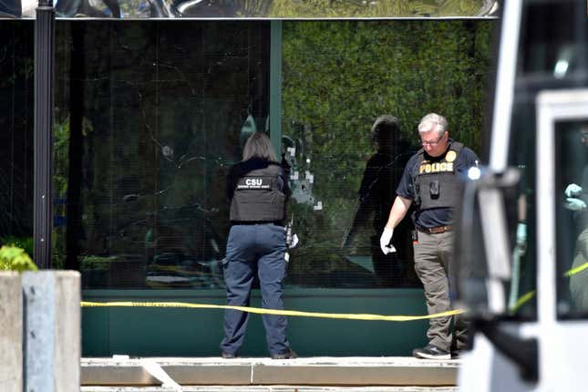 FILE - A Louisville Metro Police crime scene technician photographs bullet holes in the glass of the Old National Bank building in Louisville, Ky., April 10, 2023. The Kentucky gun shop that sold an assault weapon to a man who used it to kill five co-workers and wrote in his journal the gun was “so easy” to buy is facing a lawsuit filed Monday, Jan. 22, 2024, from survivors and families of the victims. (AP Photo/Timothy D. Easley, File)