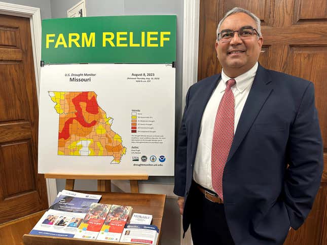 Missouri Treasurer Vivek Malek stands near a poster promoting drought conditions and state aid programs on Jan. 4, 2024, at his Capitol office in Jefferson City, Mo. Agricultural entities are among several categories of businesses that can receive low-interest loans backed by deposits of state funds made by the treasurer&#39;s office. Participation in such programs has grown in various states. (AP Photo/David A. Lieb)