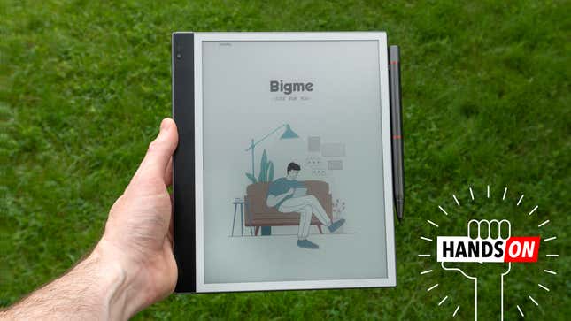The Bigme InkNote Color e-note tablet being held over a grassy lawn.