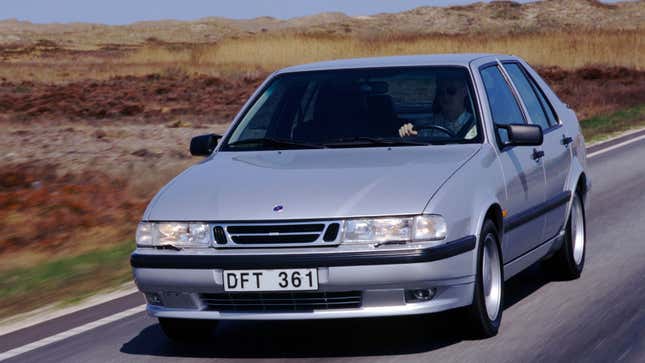 A photo of a silver Saab 9000 Aero sedan driving on a highway. 