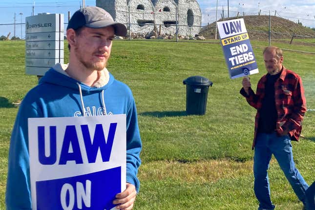 Logan Bohn, a member of the striking United Auto Workers, stands outside the Stellantis plant that makes Jeeps in Toledo, Ohio, on Friday, September 15, 2023. Bohn is a temporary worker at the plant. The UAW is seeking a contract that will end a big disparity in pay for temporary workers. (AP Photo/John Seewer)