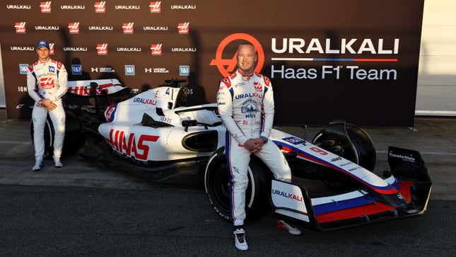 A photo of Nikita Mazepin sat on the wheel of a Haas F1 car. 