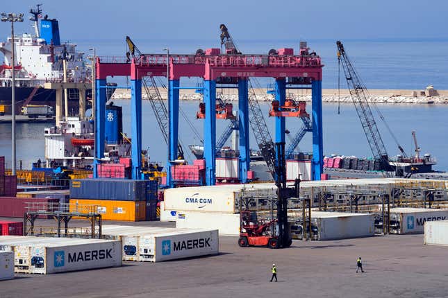 Workers walk past gantry cranes at the Beirut Port, in Beirut, Lebanon, Wednesday, March 13, 2024. Three and a half years after hundreds of tons of improperly stored ammonium nitrate ignited at the Beirut port, setting off one of the world&#39;s biggest non-nuclear explosions, Lebanese and French officials put forward a plan for reconstruction and reorganization of the port Wednesday. (AP Photo/Bilal Hussein)