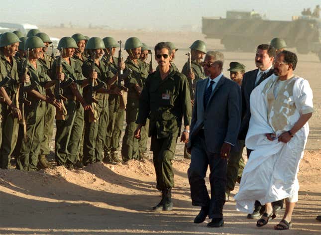 United Nations Secretary-General Kofi Annan (C) reviews troops along with Polisario Front chief Mohamed Abdelaziz (R) upon arriving to a Polisario refugee camp in Smara, Western Sahara, November 30. Annan said after talks with Polisario Front leaders that he had won a "clear yes" from them on his peace plan to resolve the long-running Western Sahara dispute. ES/CLH/ - RP1DRIFRGXAF