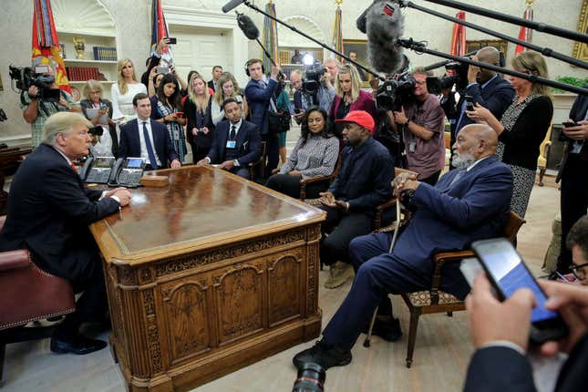  Rapper Kanye West, second right, flanked by NFL Hall of Famer Jim Brown, right, speaks during a meeting with President Donald Trump, left, in the Oval Office of the White House on October 11, 2018, in Washington, DC.