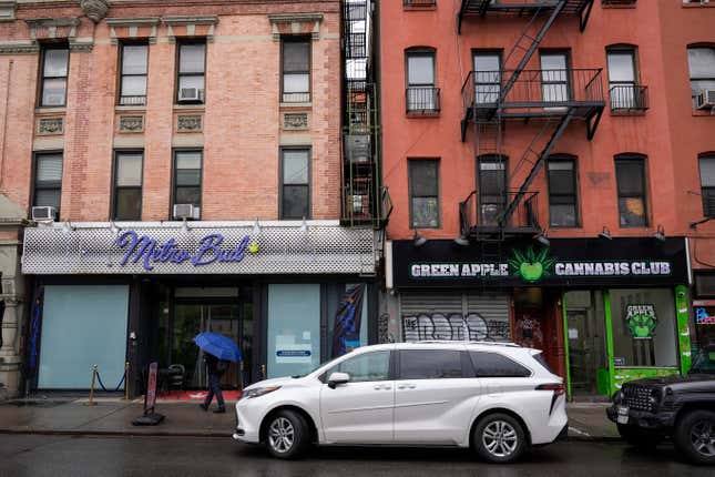 A pedestrian passes two unlicensed cannabis shops that are listed on google maps, Wednesday, Feb. 28, 2024, on the Lower East Side neighborhood of New York. Unable to reign in illegal cannabis shops in New York, the state&#39;s governor is asking digital mapping and search companies to hide or relabel the many illegal shops. (AP Photo/Mary Altaffer)