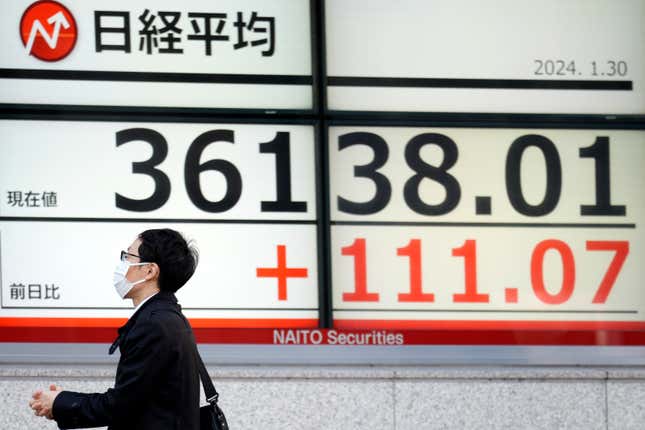 A person walks in front of an electronic stock board showing Japan&#39;s Nikkei 225 index at a securities firm Tuesday, Jan. 30, 2024, in Tokyo. Asian shares were mixed on Tuesday, with Hong Kong and Shanghai leading declines, ahead of a decision by the Federal Reserve this week on interest rates. (AP Photo/Eugene Hoshiko)