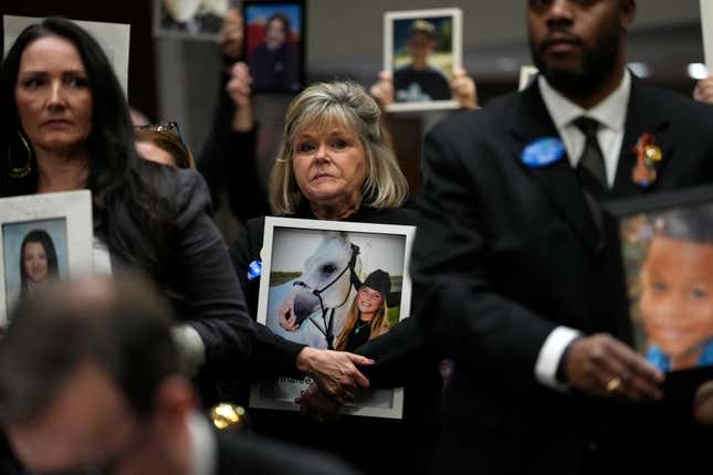 People hold photos of their loved ones as they sit in the audience before the start of a Senate Judiciary Committee hearing with the heads of social media platforms on Capitol Hill in Washington, Wednesday, Jan. 31, 2024, to discuss child safety. (AP Photo/Susan Walsh)