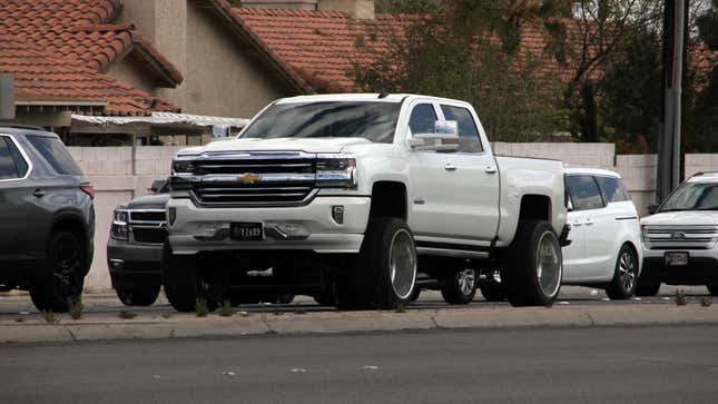 A modified white Chevrolet Silverado High Country stopped on West Craig Road, North Las Vegas, Nevada. It appears to be a 2016-18 1500 with tow mirrors, "Carolina squat" style lift, and aftermarket rims.